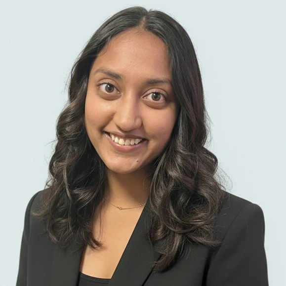 Professional headshot of Mahek Bansal, smiling and wearing business attire against a neutral background.